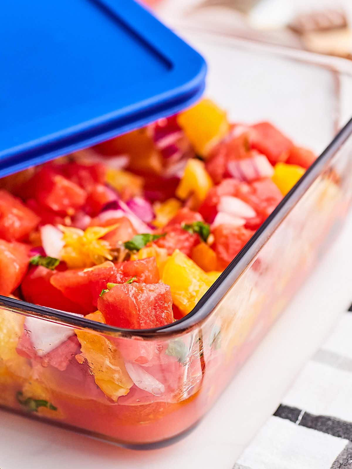 Transferring the Watermelon and Orange Salad into an airtight storage container.