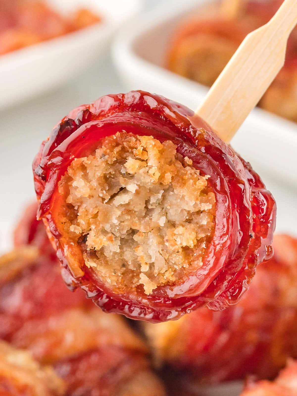 Closeup of a Bacon Stuffing Roll on a wooden stick.