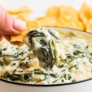 A bowl of creamy Spinach Dip with Nachos chips for dipping.