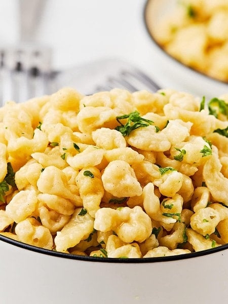 Cooked German Spätzle (egg noodles) in a white bowl.