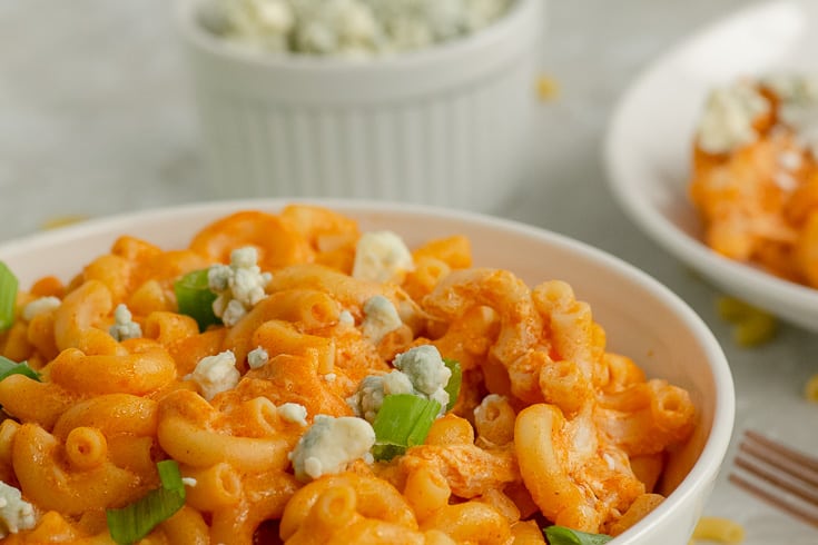 A closeup of a bowl of warm buffalo chicken mac and cheese