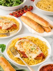 A plate of chicken parmesan spaghetti and meatballs.