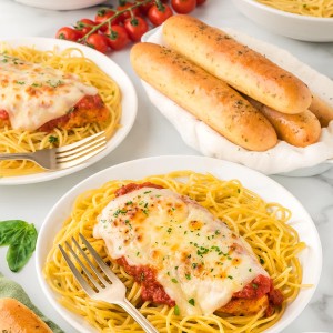 A plate of chicken parmesan spaghetti and meatballs.