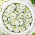 Topdown view of a Creamy German Cucumber Salad served in a white bowl.