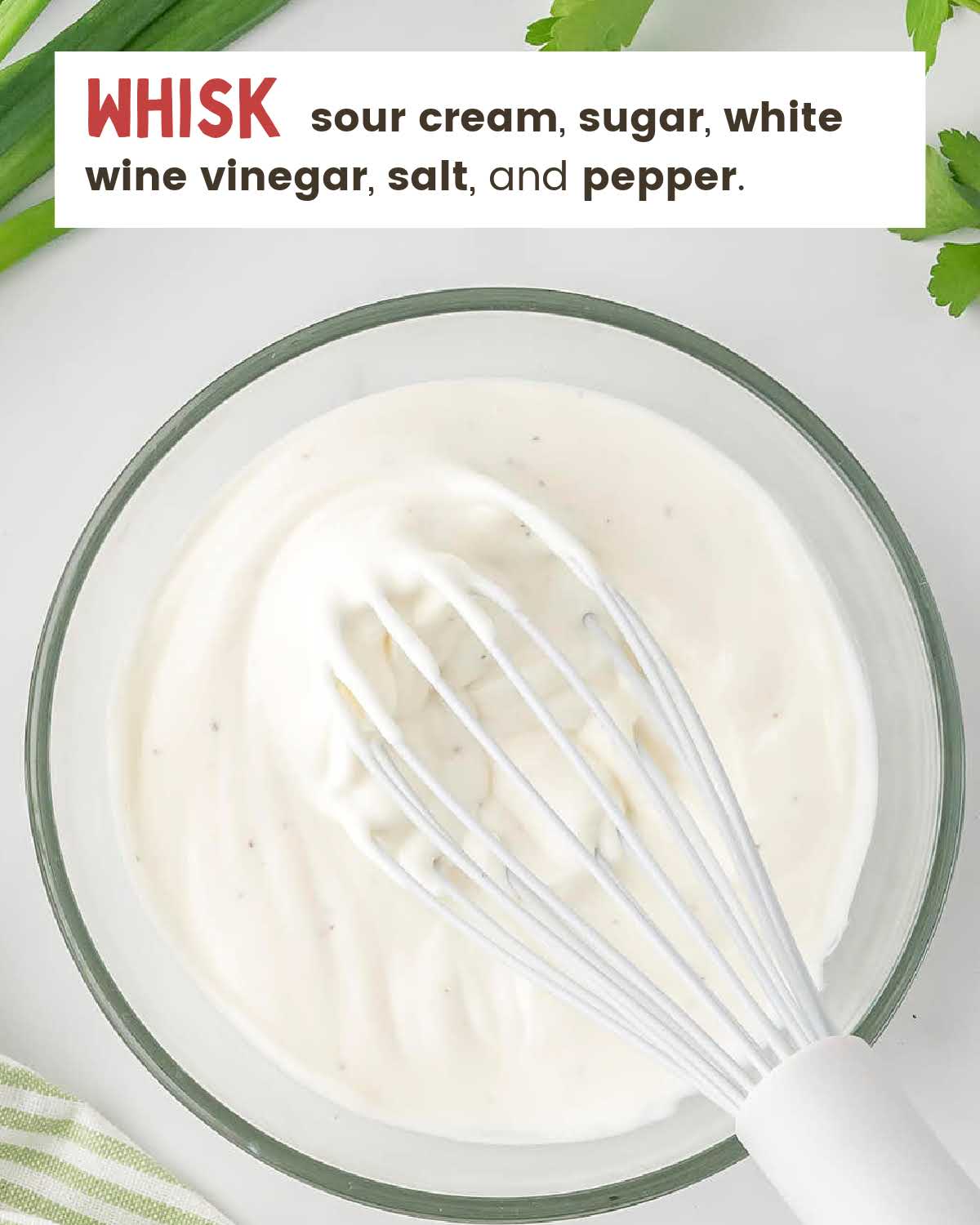 A whisk in a bowl of creamy homemade dressing.