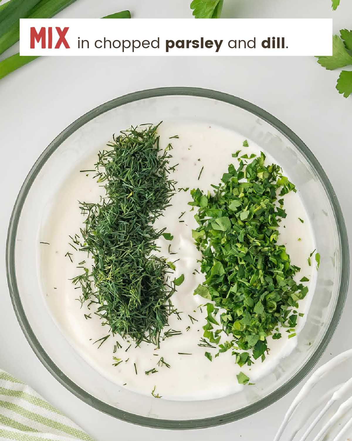 Chopped parsley and dill on a bowl of homemade creamy dressing.