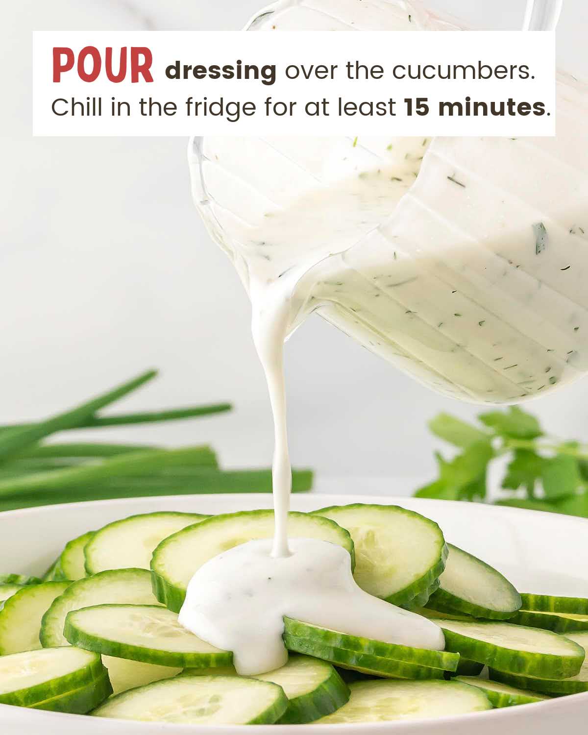 Homemade creamy dressing poured over sliced cucumbers in a bowl.