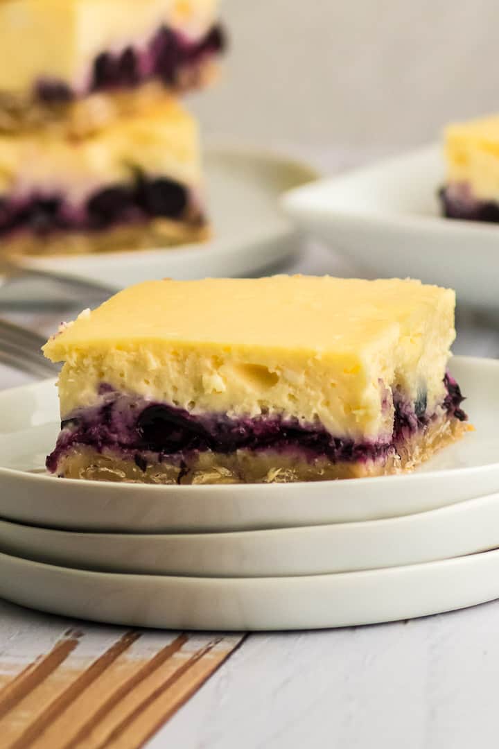 a blueberry cheesecake bar on a white plate