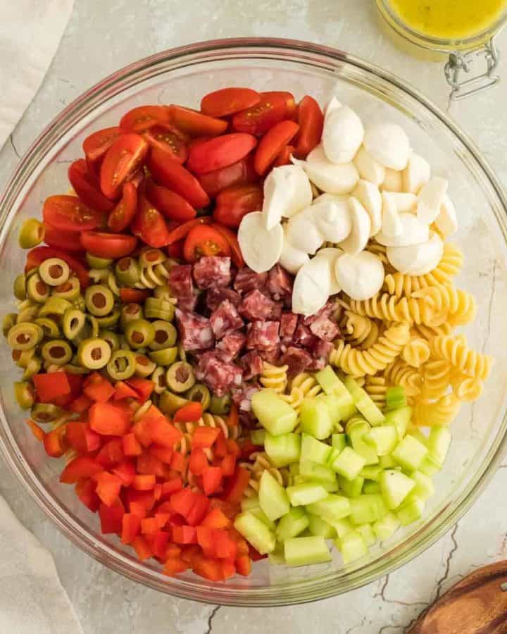 a large salad bowl filled with all the ingredients needed to make Italian Pasta Salad