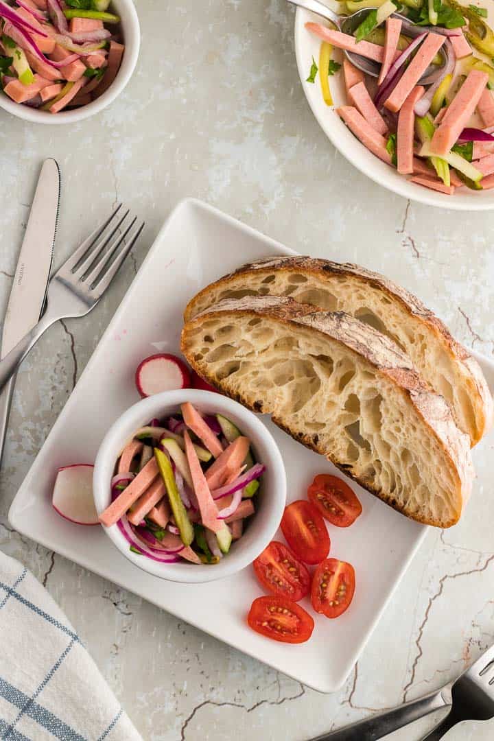 a bowl of German Wurstsalat with a side of crusty bread