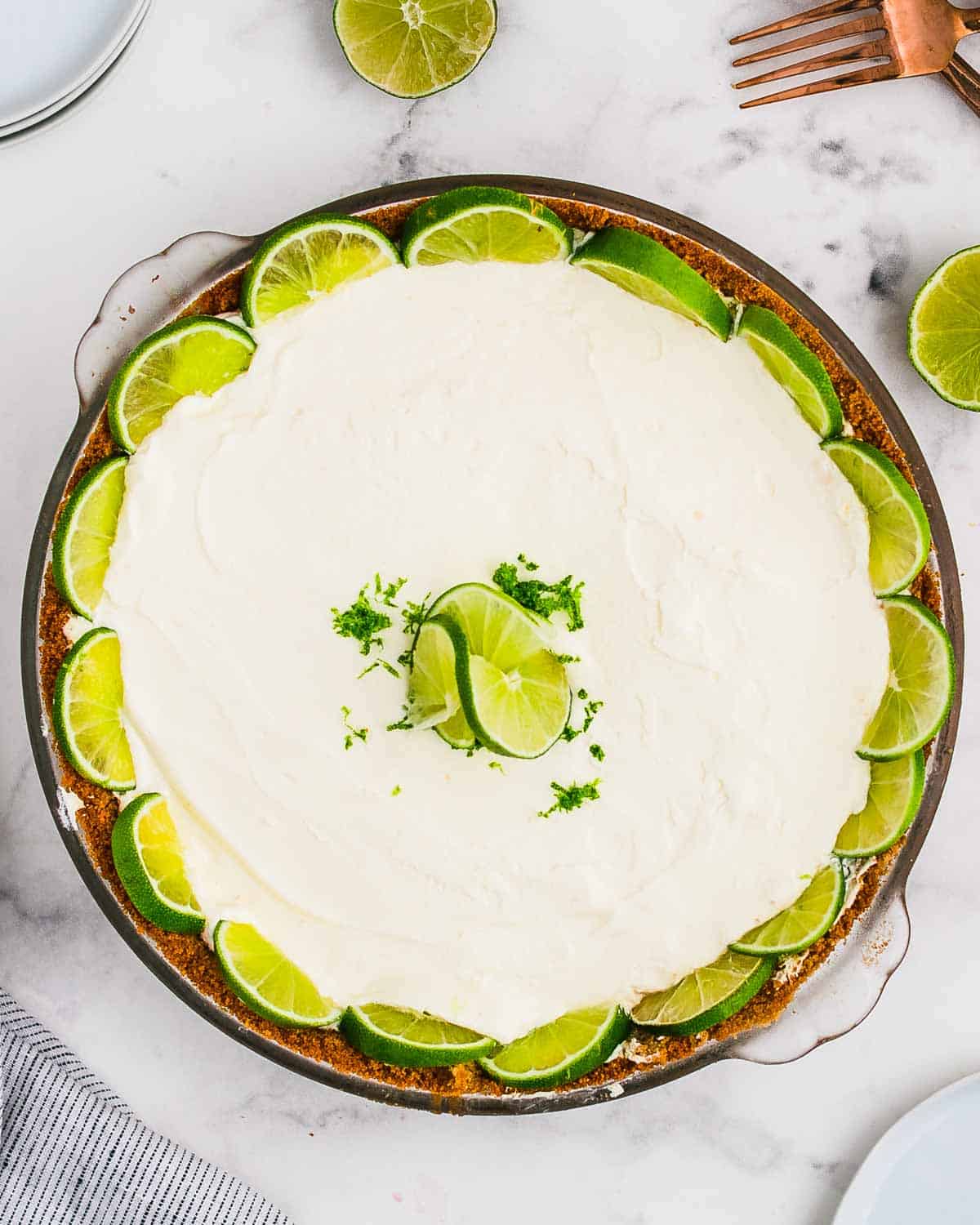 Top down view of a Key Lime Pie decorated with fresh limes.