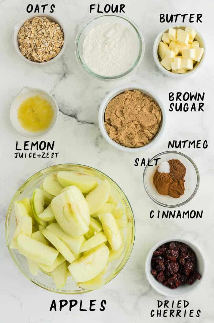 Ingredients needed to make Apple Crisp: Oats, Flour, Butter, Lemon (zest + juice), brown sugar, salt, nutmeg, cinnamon, apples, dried cherries