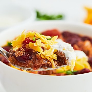 A forkful of Ground Beef Chili with sour cream on cheese.