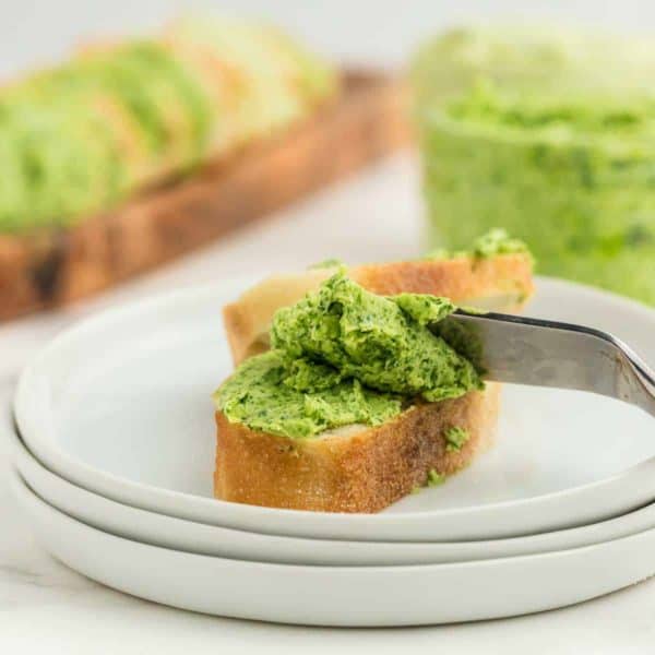 parsley butter on a slice of baguette served on a white plate