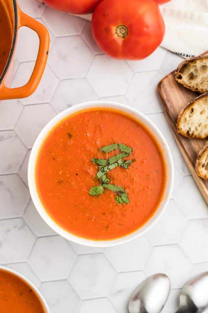 a bowl of fresh tomato soup topped with fresh basil