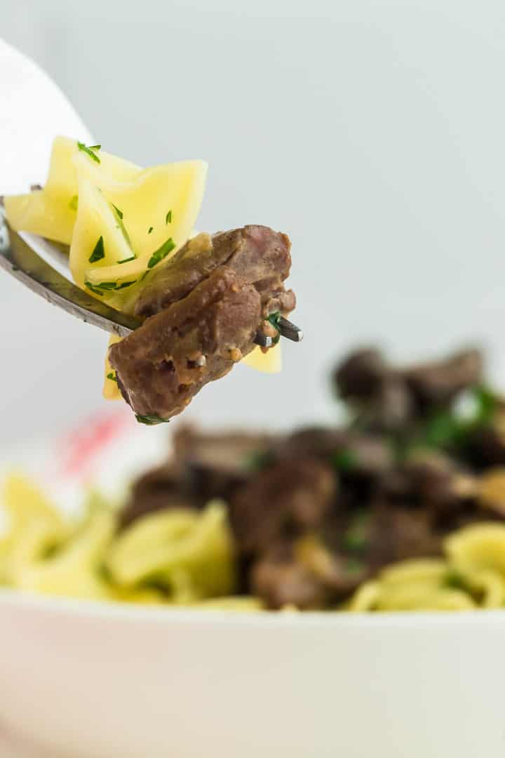 a forkful of beef stroganoff and parsley noodles