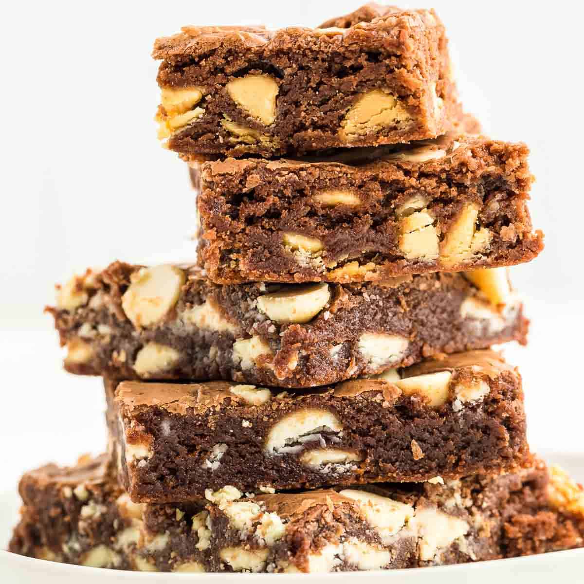 A stack of freshly baked White Chocolate Chip Brownies on a white plate