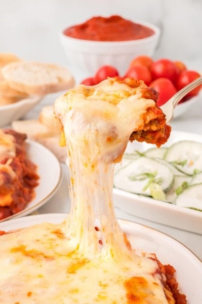 A spoonful of extra cheesy Lazy Lasagna served on a white plate.