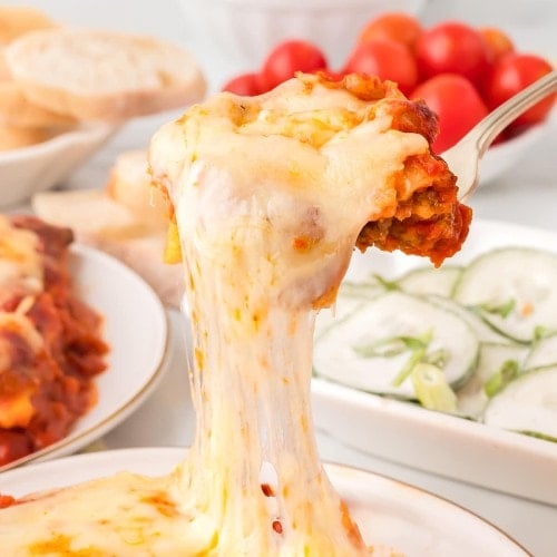 A spoonful of extra cheesy Lazy Lasagna served on a white plate.