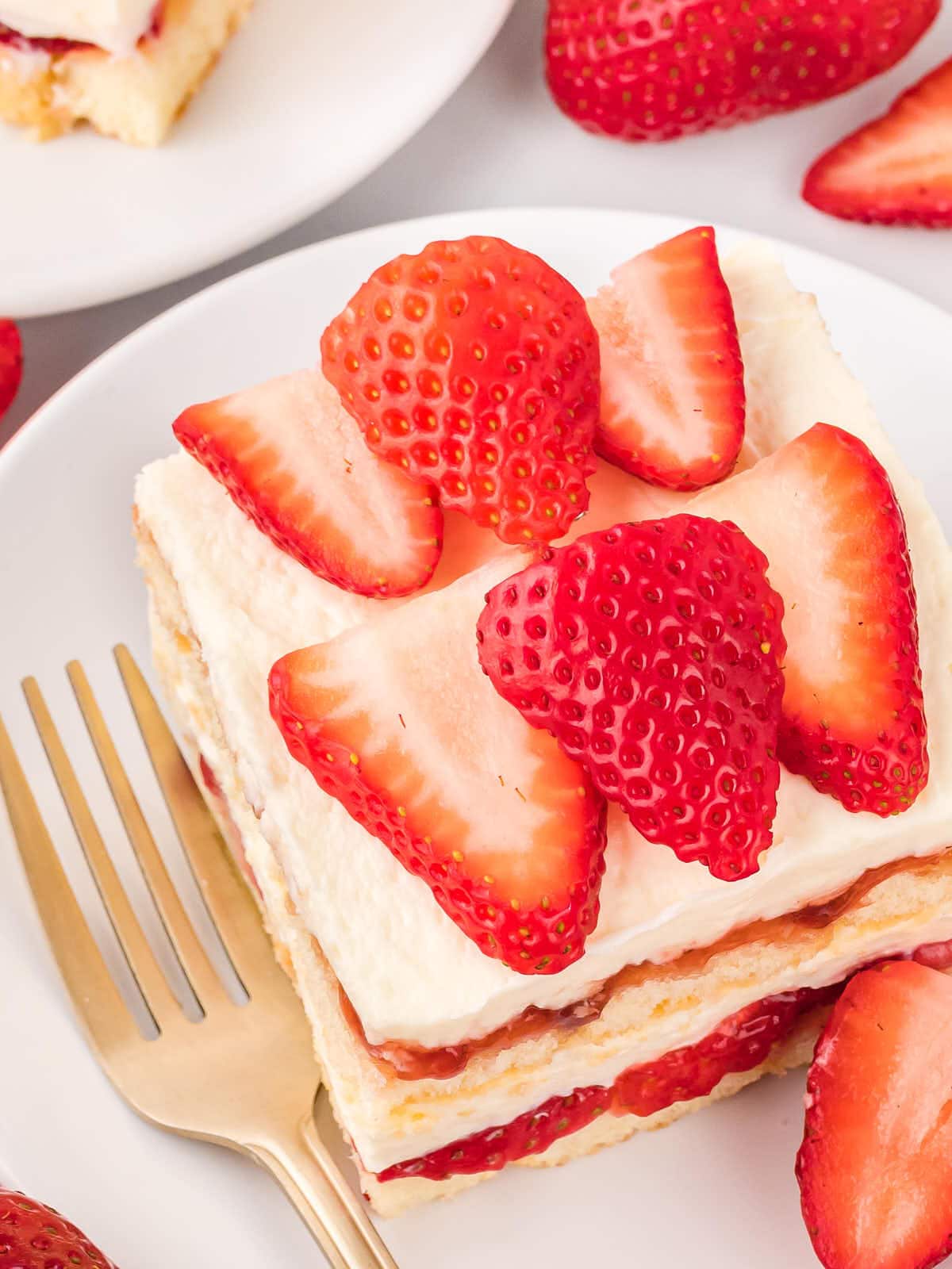 Topdown view of a slice of Strawberry Tiramisu on a white plate.