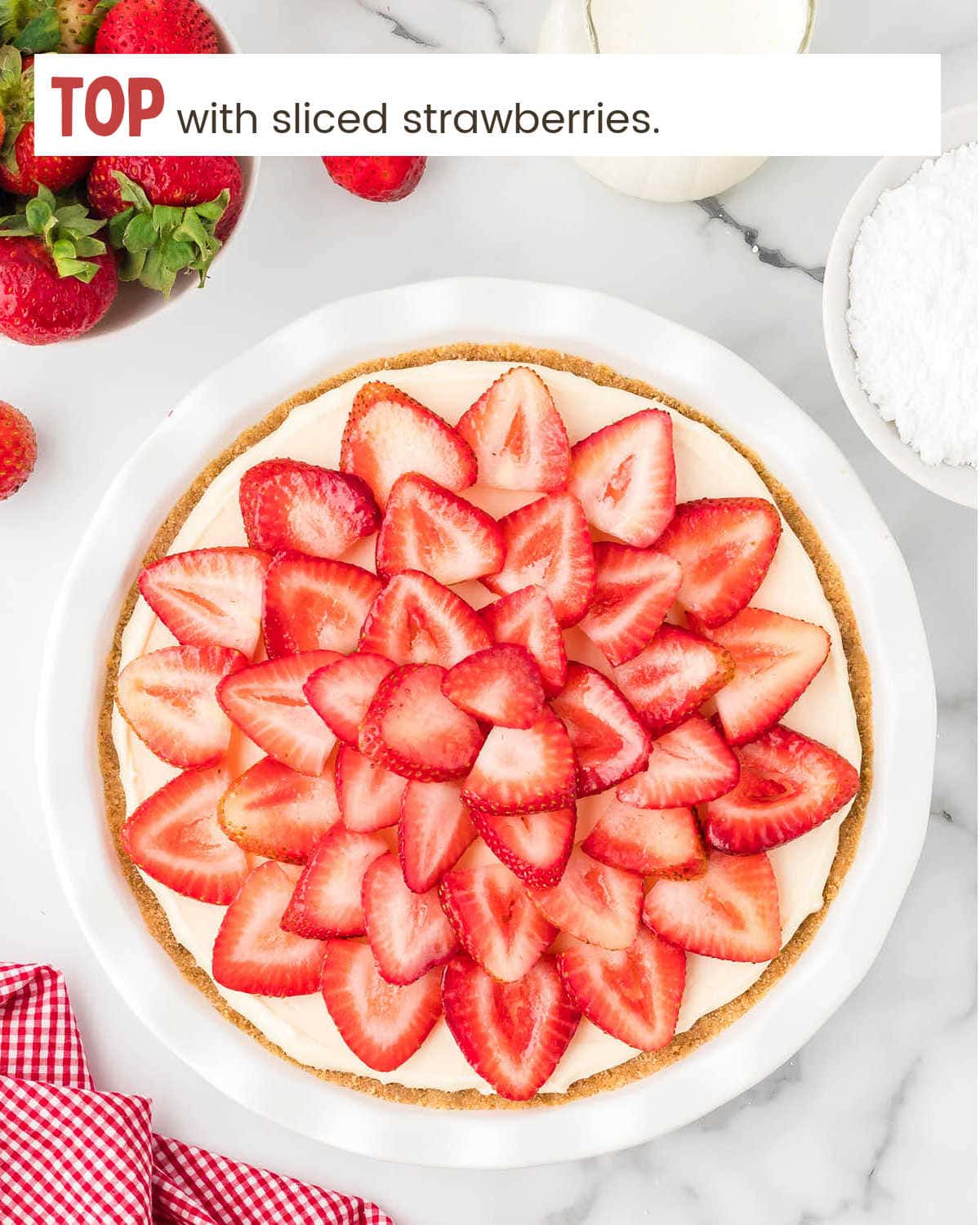 Topping no bake pie with strawberries.