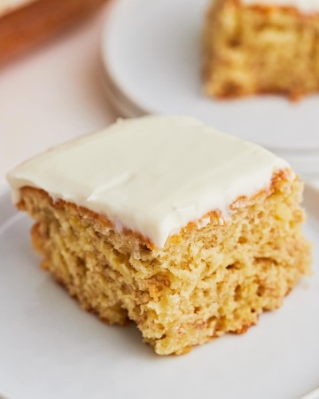 A slice of Banana Cake on a plate with icing.
