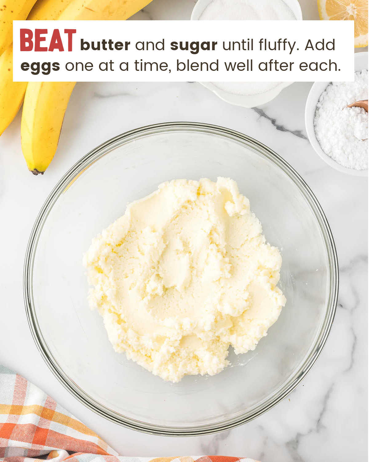Creaming together butter and sugar for Banana Cake in a glass bowl.
