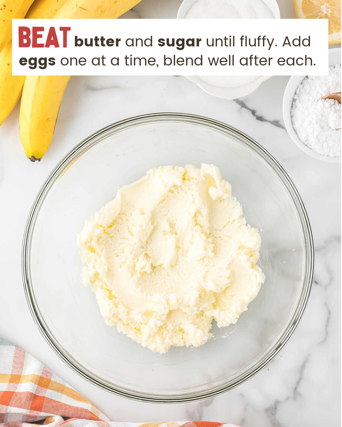 Creaming together butter and sugar for Banana Cake in a glass bowl.