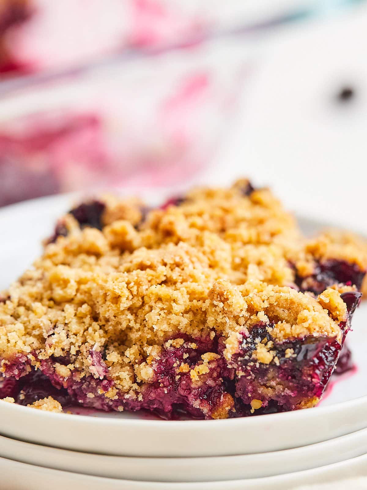 A plate of blueberry crumble, also known as blueberry crisp, on a white plate.