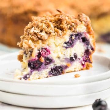 a slice of freshly baked blueberry coffee cake on a white plate