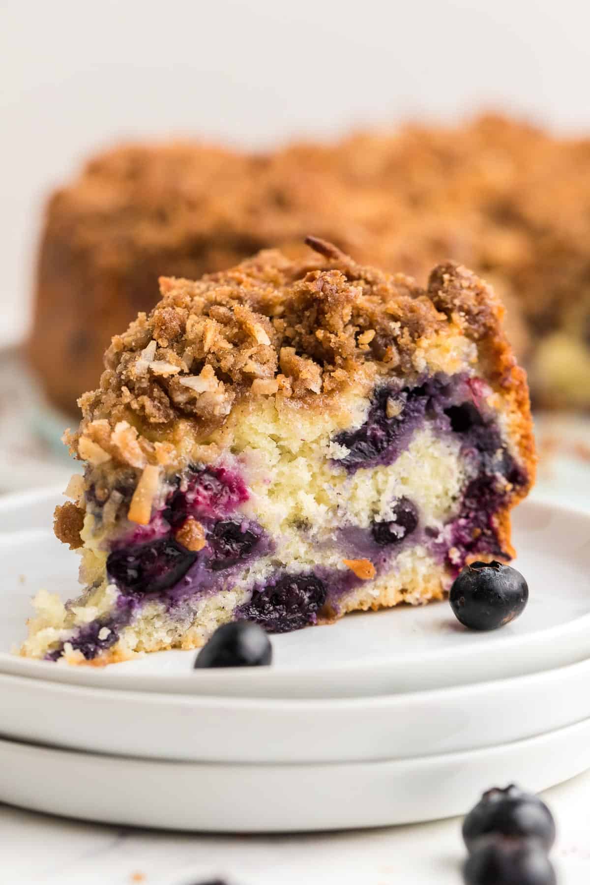 A slice of Blueberry Coffee Cake on a white plate.