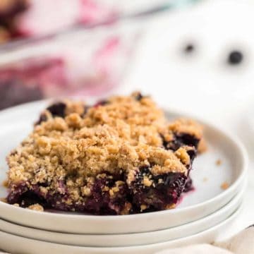 a slice of blueberry crisp on a white place