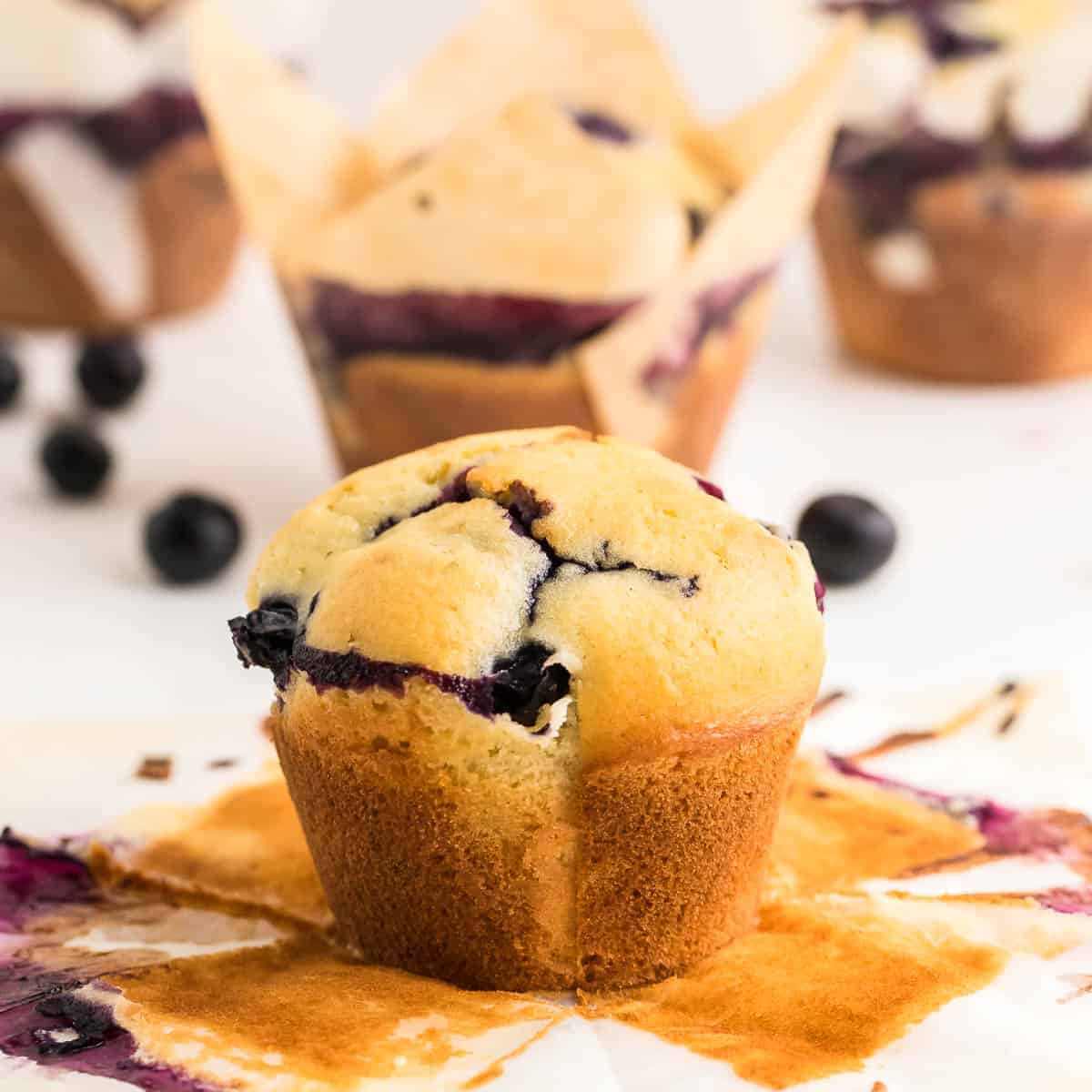 A closeup image of a freshly baked blueberry muffin with the liner removed.