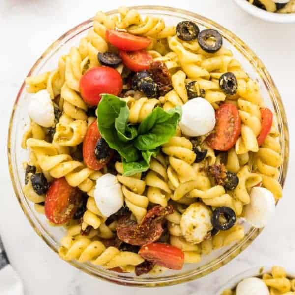 Freshly made Pesto Pasta Salad in a glass serving bowl.