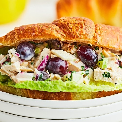 Chicken Salad served in a croissant on a white plate.