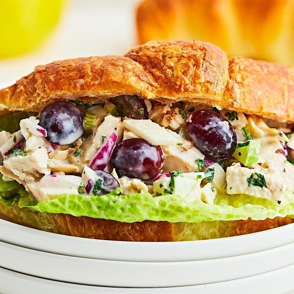 Chicken Salad served in a croissant on a white plate.