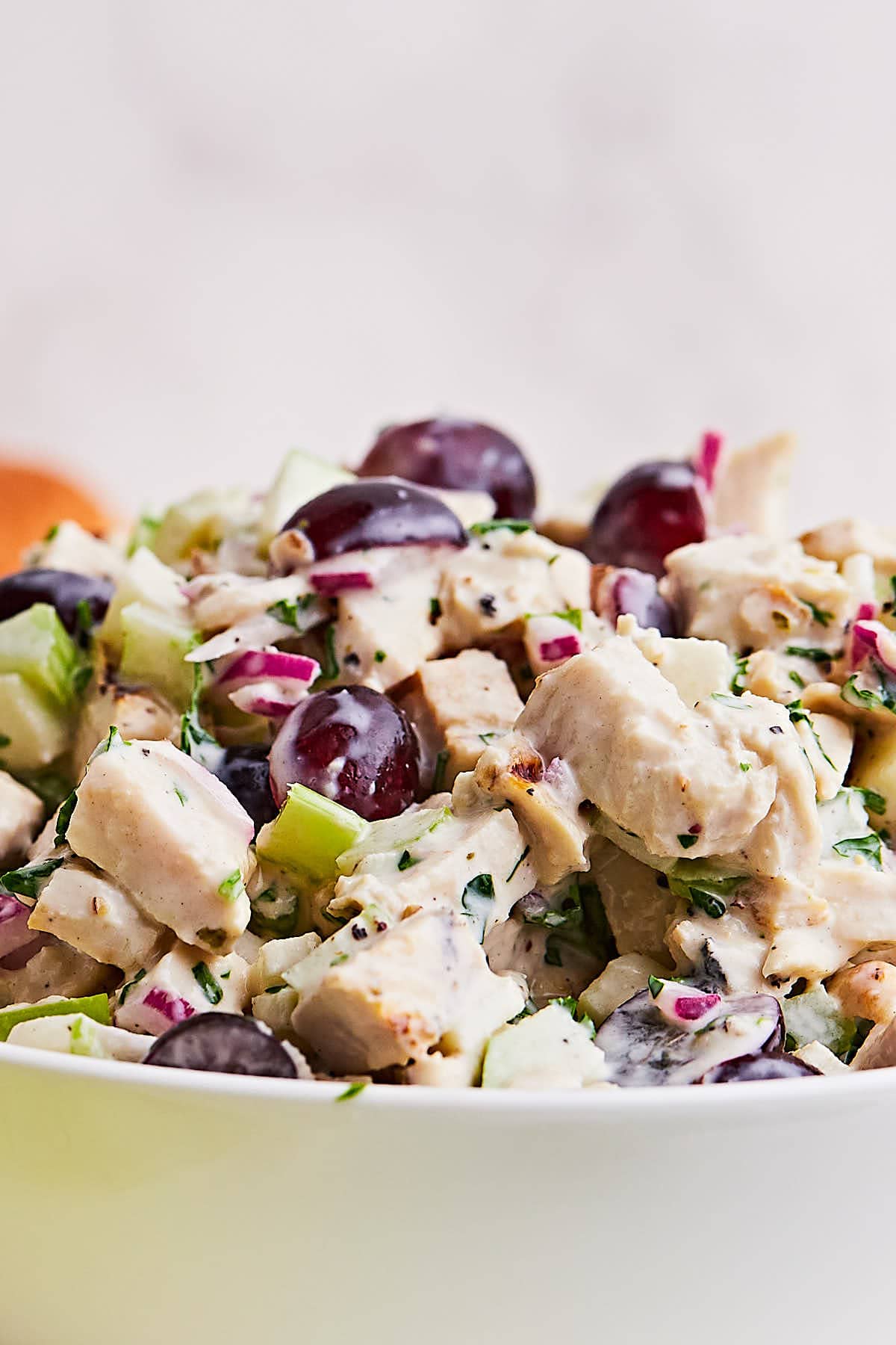 Creamy Chicken Salad with grapes in a white bowl.