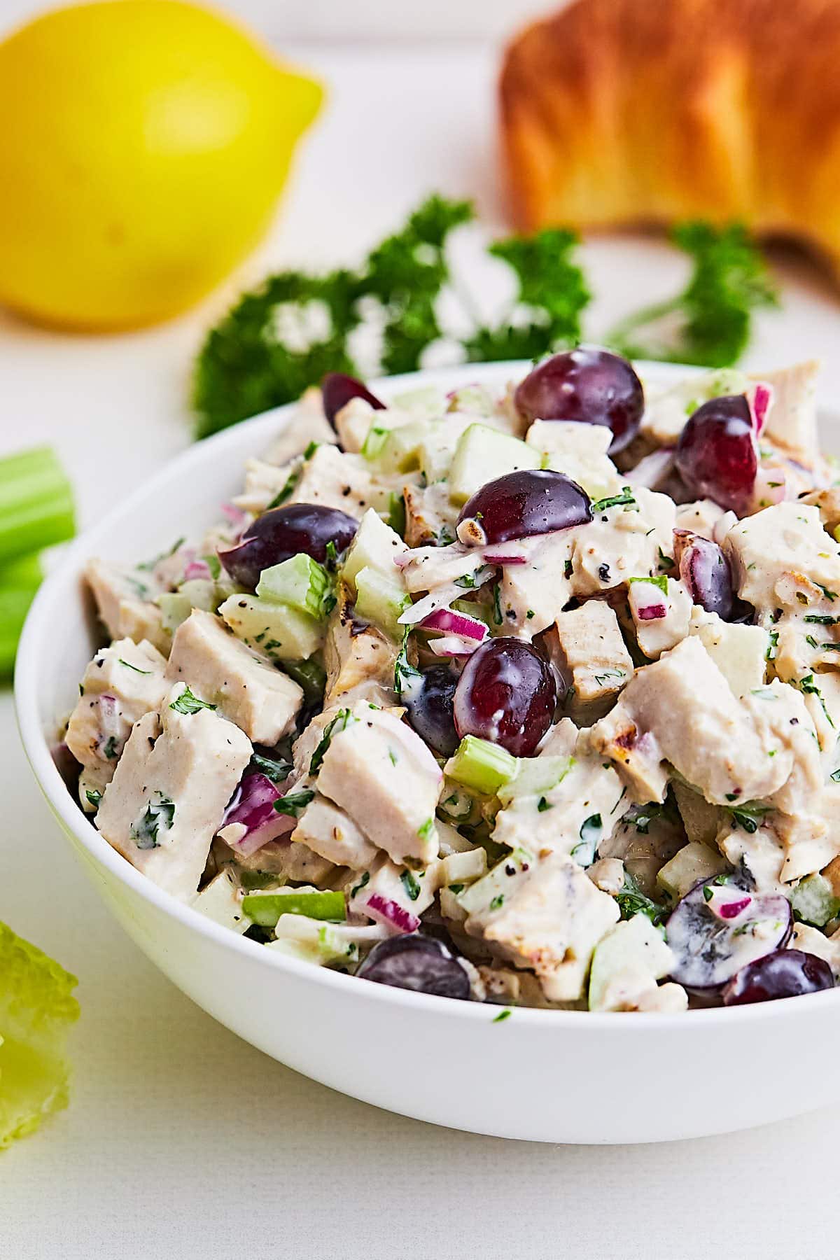 Creamy Chicken Salad with grapes in a white bowl.