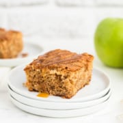 A slice of freshly baked Apple Cake drizzled with caramel sauce.