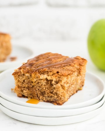 a slice of freshly baked apple cake drizzled with caramel sauce