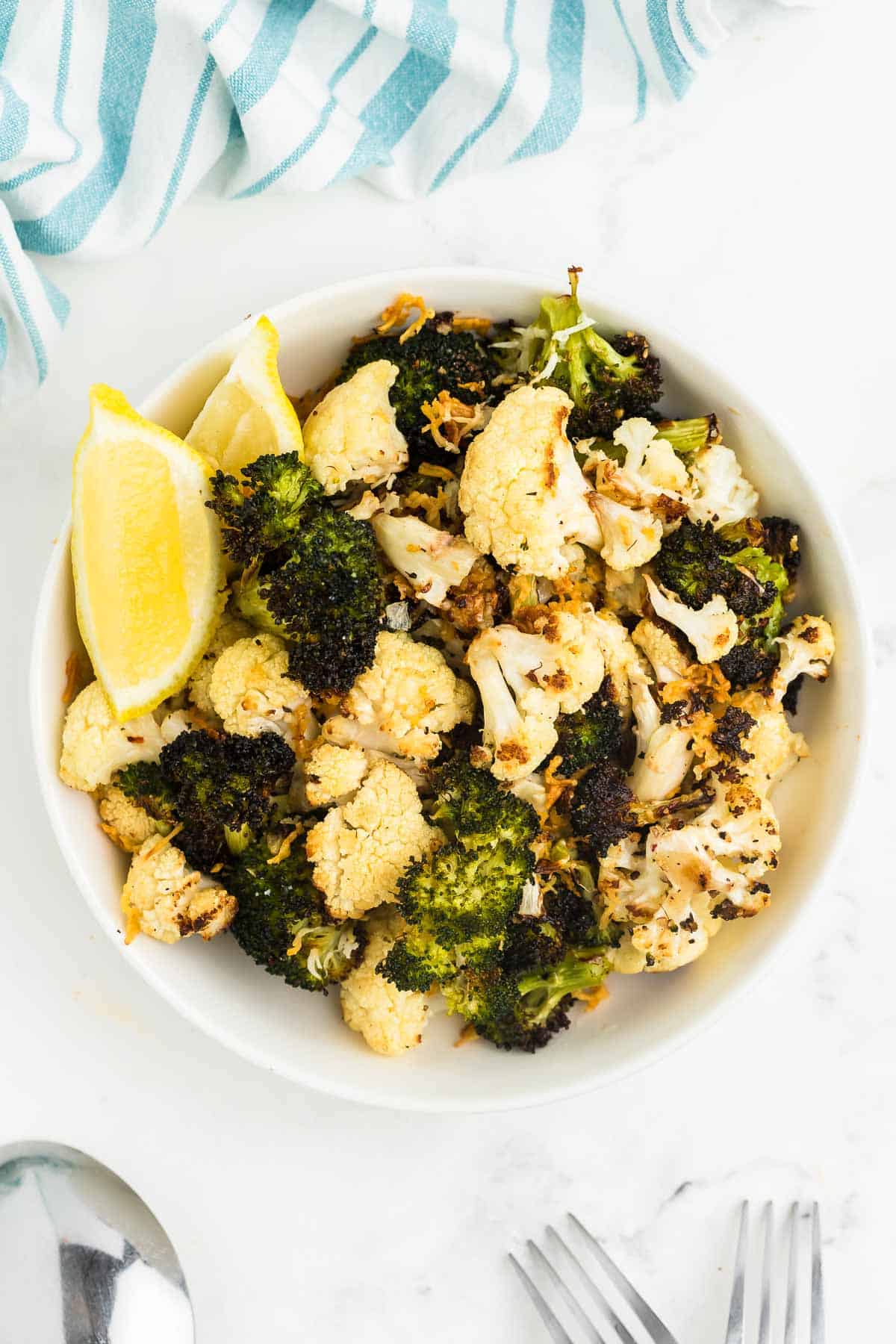 top down view of roasted broccoli and cauliflower in a white bowl