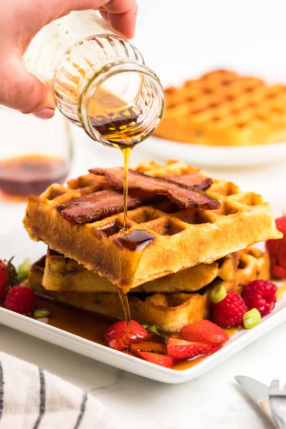 drizzling warm maple syrup over the waffles