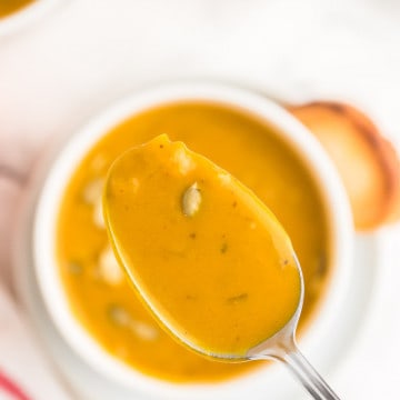 a spoonful of last minute pumpkin soup taken from a white bowl