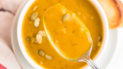 a spoonful of last minute pumpkin soup taken from a white bowl
