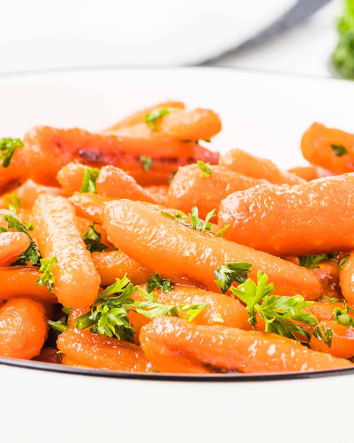 glazed candied carrots in a white bowl