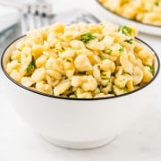 A plate of homemade Spätzle drizzled with parsley.