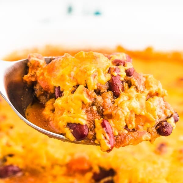 Taking a spoonful out of the freshly baked casserole