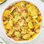 Close-up of Warm German Potato Salad with sliced potatoes in a bacon dressing.