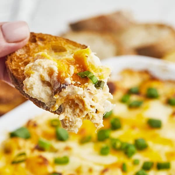 A slice of bread dipped in hot crab dip.