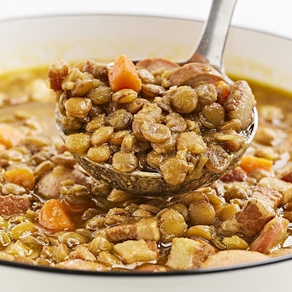 A spoonful of lentil soup with sausage.